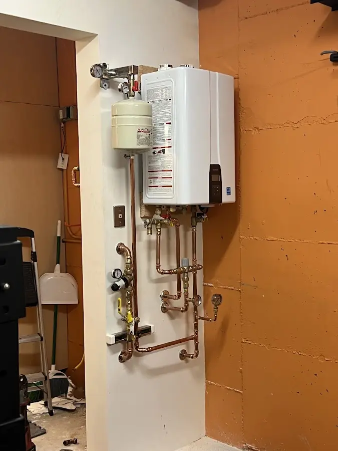 Plumbing technician inspecting water heater connections in South Amboy